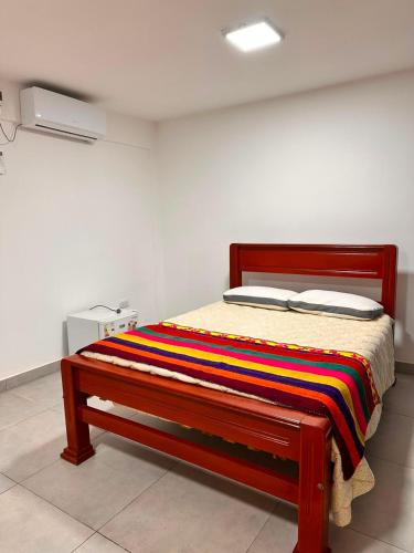 a bed with a colorful blanket on it in a room at Habitación Privada in Libertador General San Martín