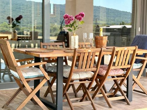 a wooden table and chairs with flowers on it at Pannon Grace Balaton in Dörgicse