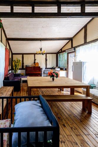 a living room with a wooden table and a couch at Pie lacuksa in Tīnūži