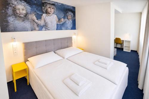 a bedroom with a white bed and a painting on the wall at Hotel CHODOV ASC in Prague