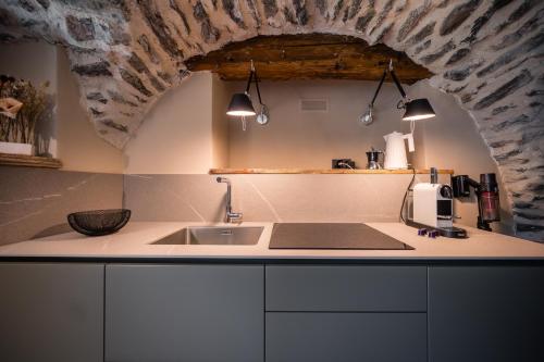 a kitchen with a sink and a stone ceiling at Granuit Alpine Home in Sauze di Cesana