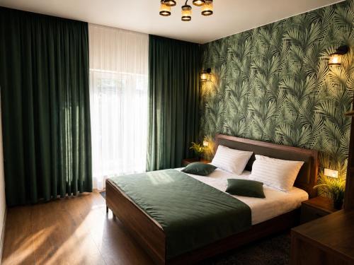 a bedroom with a bed with a green wallpaper at Stop Time in Slavske