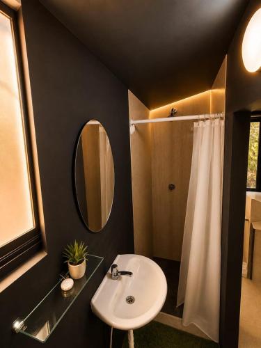 a bathroom with a sink and a mirror and a shower at Panama Experience Hostal in Panama City