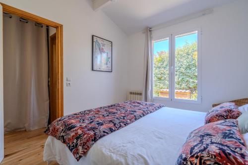 a bedroom with a bed and a window at Chalet Cosy in Lège-Cap-Ferret