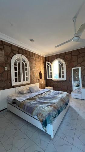 a bedroom with a large bed in a stone wall at luxor nile palace in Luxor