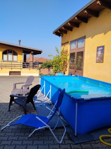a large swimming pool with two chairs and a table at Dimora Gundin in Govone