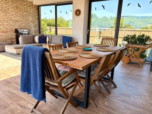 a dining room table with chairs and a couch at Pannon Grace Balaton in Dörgicse