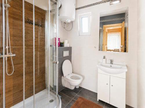 a bathroom with a toilet and a sink and a shower at Domki nad Soliną 665-189-444 OGRZEWANE in Solina