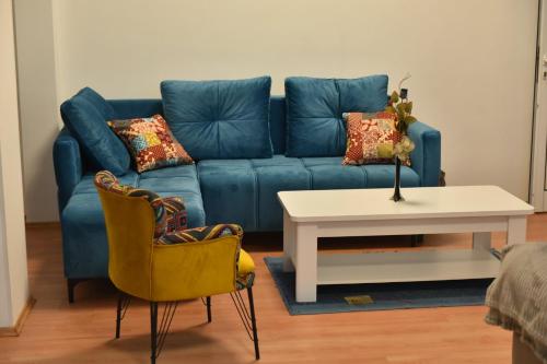 a blue couch in a living room with a table and chairs at Peron in Nikšić
