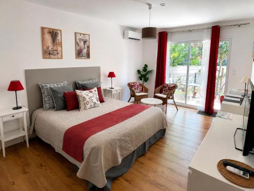 a bedroom with a large bed with red curtains at Lou Meinado, un concept "comme à l'hôtel" in Saint-Martin-de-Crau