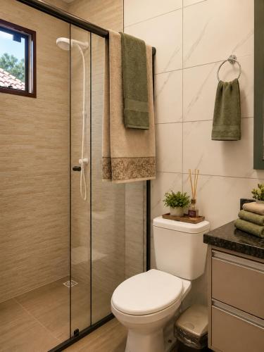 a bathroom with a toilet and a shower at Refúgio Rural Ipê Lago e Fogueira ao Ar Livre in Campo Alegre