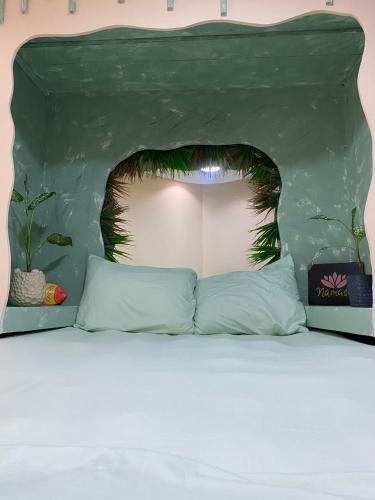 a bed in a room with a green headboard at Panama Experience Hostal in Panama City