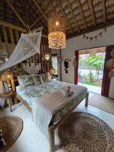 a bedroom with a bed and a chandelier at Mandala House - Kite Village in Icaraí