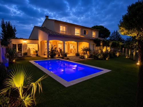 a house with a blue pool in the yard at Lou Meinado, un concept "comme à l'hôtel" in Saint-Martin-de-Crau
