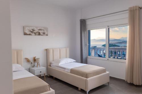 a bedroom with two beds and a large window at Cloud Nine Retreat, Ksamil in Ksamil