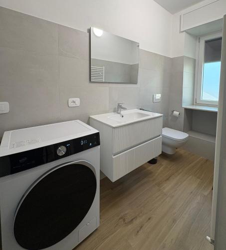 a bathroom with a sink and a washing machine at LA CASETTA - Clusone in Clusone