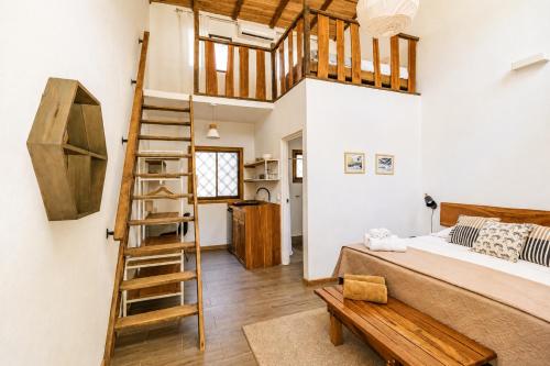 a loft bedroom with a bed and a ladder at Believe Surf & Yoga Lodge Santa Teresa in Santa Teresa Beach