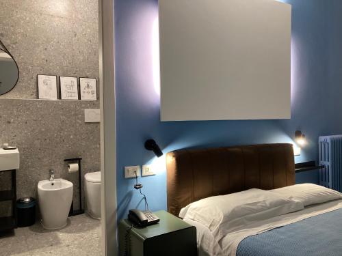 a bedroom with a bed and a bathroom with a sink at Hotel Calypso in Milan