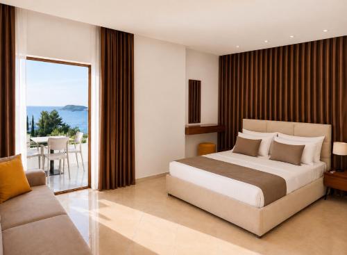 a bedroom with a bed and a couch and a balcony at Dine Hotel in Ksamil