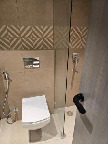 a bathroom with a toilet and a glass shower at SriVa Nest in Ghaziabad
