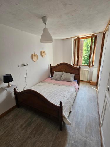 a bedroom with a bed and a window at relais de la diligence in Morteau