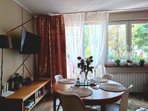 a dining room with a table and a large window at Chillroom in Rąbień