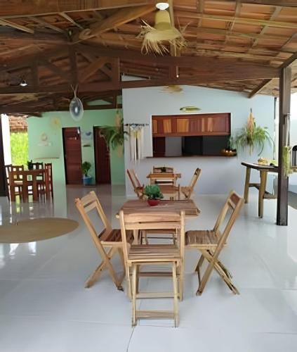 a dining room with a wooden table and chairs at Villa of the Palm Trees in Icaraí