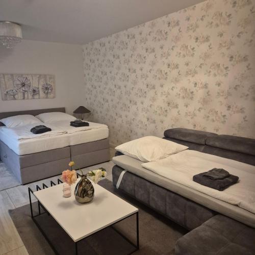a bedroom with two beds and a table with flowers on it at Landwiese in Landkern