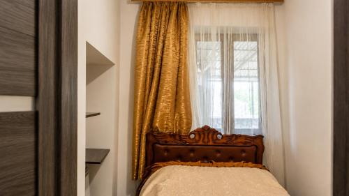 a bedroom with a bed and a window with curtains at Syune House in Tatʼev