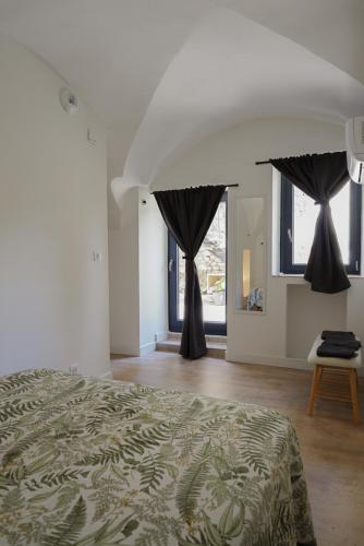 a bedroom with two black drapes and a bed at Le Loft in Sainte Anastasie - Aubarne