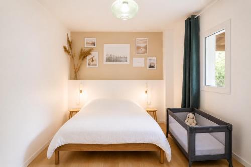 a bedroom with a bed and a window at La Cachette du Lac - Parenthèse nature entre piscine, lac & océan in Lacanau