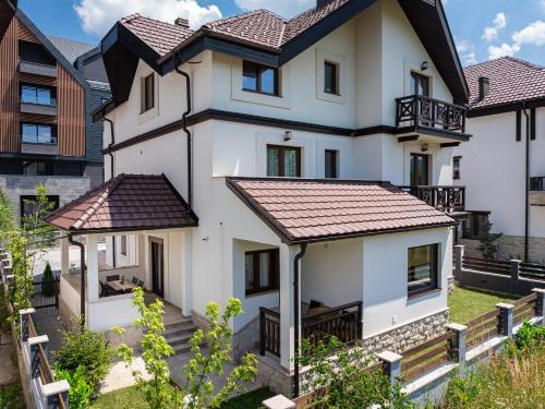 a white house with a brown roof at MonteBreza Spa Apartment Jacuzzi, Sauna & Free Parking in Kolašin