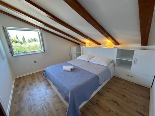 a small bedroom with a bed and a window at Blue Wave Apartments - Adriatic in Slano