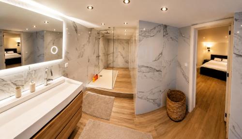 a bathroom with a tub and a sink and a mirror at B&B The Parklane Retreat in Schoten