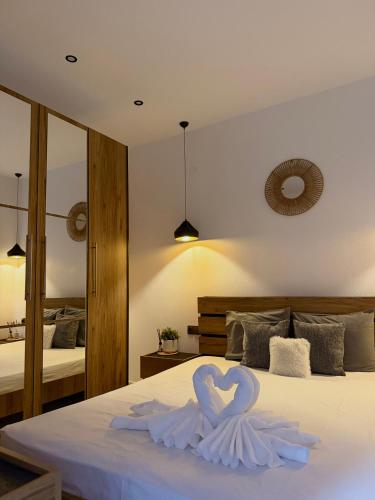 a bed with a heart made out of white swans at Emerald Dream Oasis Studio in Skala Potamias