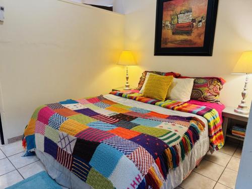 a bedroom with a colorful quilt on a bed at Ocean Light at Villa Hermosa in San Carlos