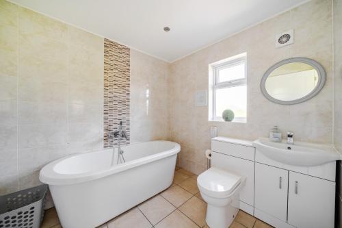 a bathroom with a tub and a toilet and a sink at Sage Lodge in Brigg