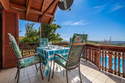 a patio with a table and chairs on a deck at Pool Chalet Adonis w/ Panoramic Views - Happy Rentals in Semič