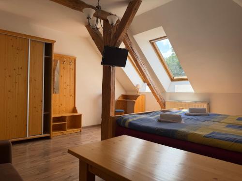 a bedroom with a bed and a table in a room at Hotel Atawa in Raby
