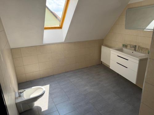 a bathroom with a sink toilet and a window at Hotel Atawa in Raby