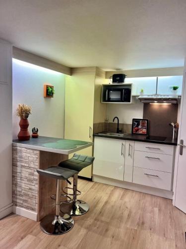 a kitchen with a counter and a table in a room at Etablissement Cloutiers comprenant plusieurs logements de type studio - Hyper Centre Brive in Brive-la-Gaillarde