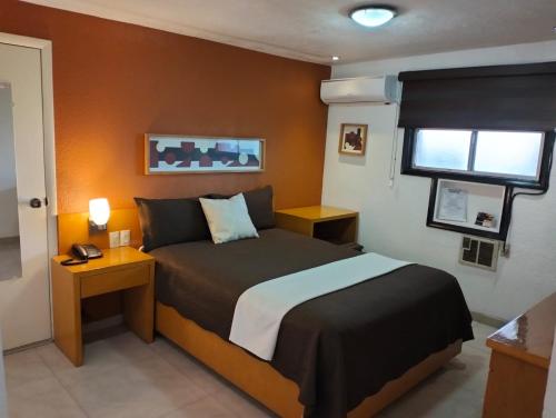 a bedroom with a large bed and a window at Hotel Regis in Mexicali