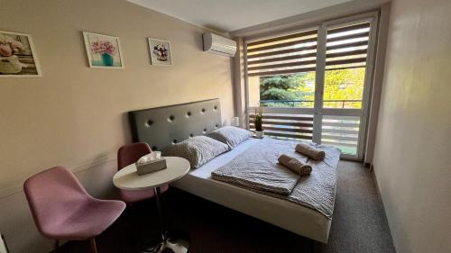 a bedroom with a bed with a table and a window at NASZE BIAŁE pokój 2 osobowy in Okuninka