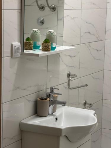 a white bathroom with a sink and a mirror at M&M Trebinje in Trebinje