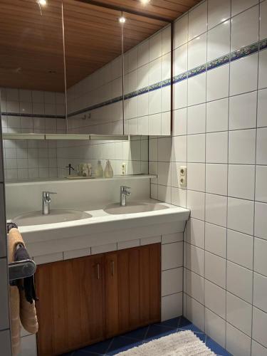 a bathroom with two sinks and a mirror at Sissy Appartment in Kössen