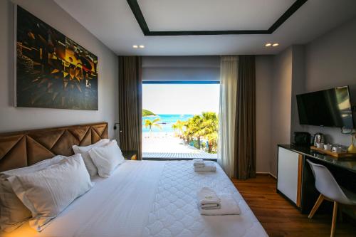 a bedroom with a bed with a view of the beach at King Hotel Ksamil in Ksamil