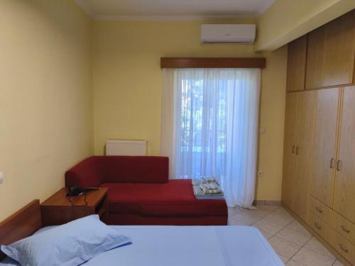 a living room with a red couch and a window at Vania's apartment in Preveza