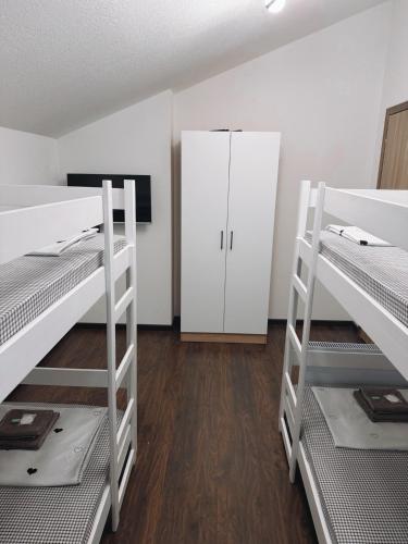 a room with three bunk beds and a cabinet at M&M Trebinje in Trebinje