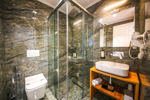a bathroom with a shower and a toilet and a sink at King Hotel Ksamil in Ksamil