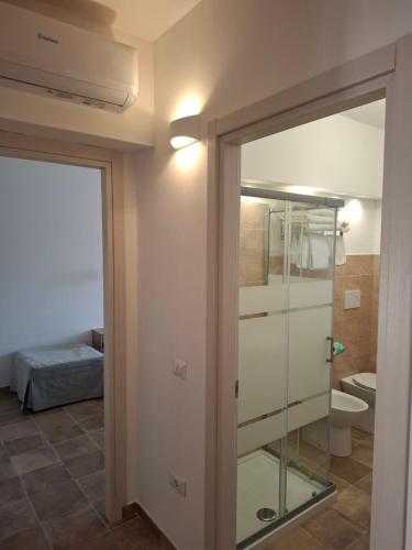 a bathroom with a glass door leading to a bedroom at Domus Cassia in Cascia